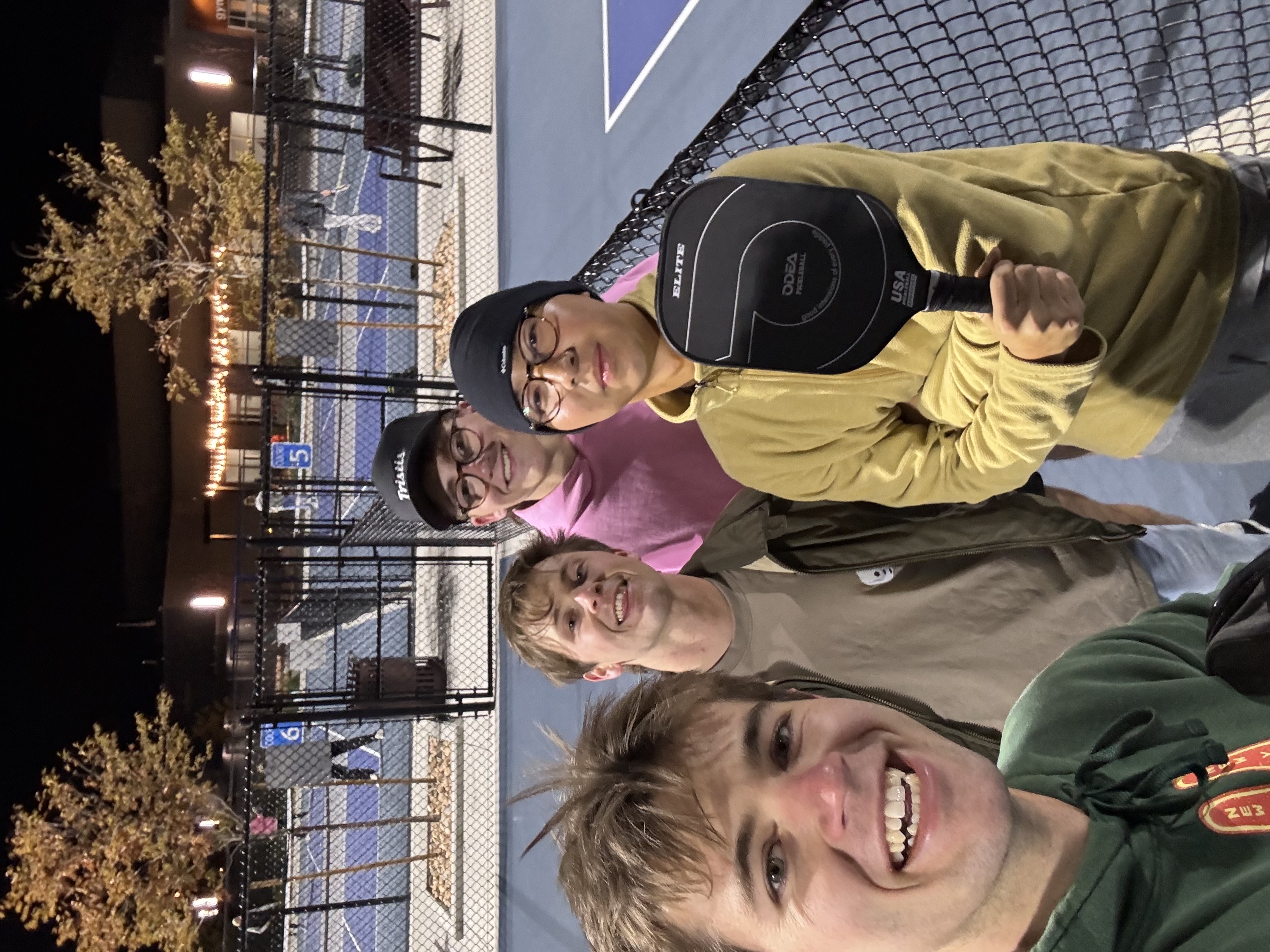 Friends at the pickleball courts at night